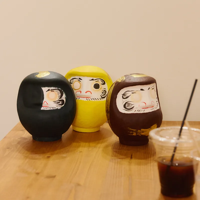 参加者が制作した黒、黄、茶色のだるま作品