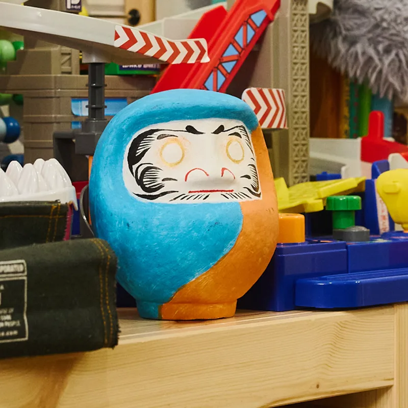 青いだるま作品を制作台に置いた様子