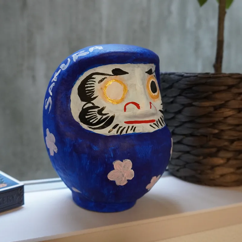 青いだるま作品を棚に飾った様子
